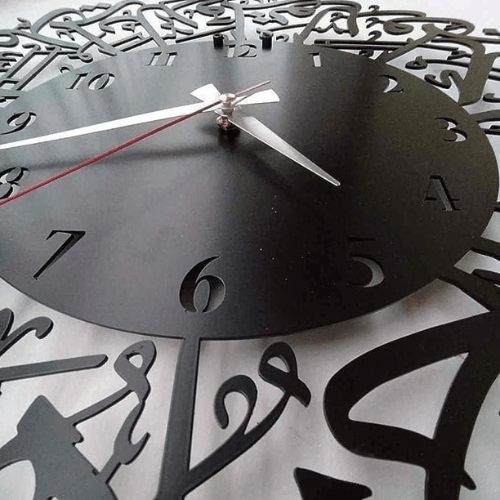 Decorative wall clock with intricate cut-out design on a white background