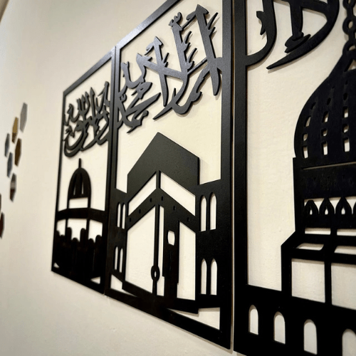 Decorative metal wall art with architectural silhouettes on a white background